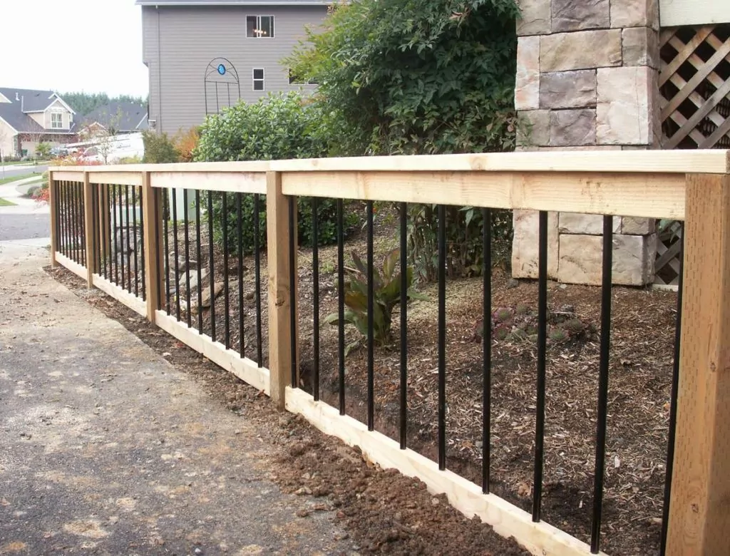 Wood frame fence with wrought iron spindles to illustrate fence ideas for house
